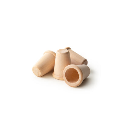 Group of five unfinished birch wood thimbles, one lying in front showing the interior hole, natural wood tone